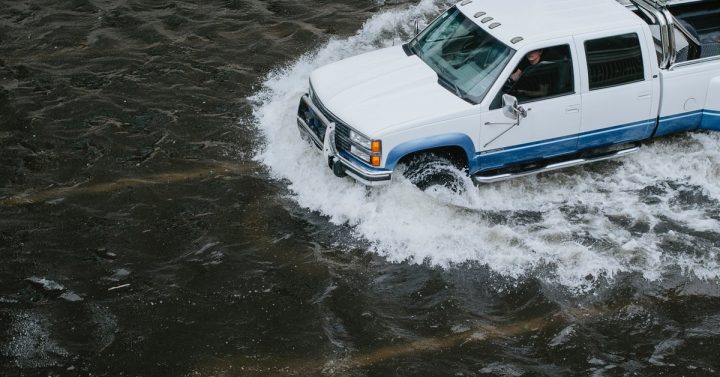 White truck driving through flooded street