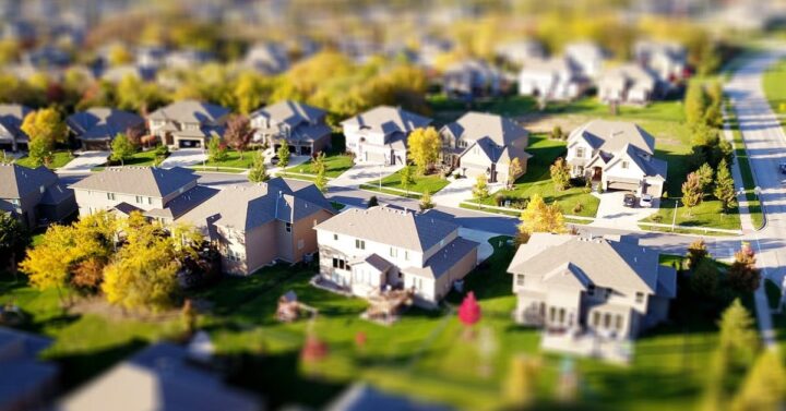 Birds eye view of neighborhood with light-colored houses and several trees