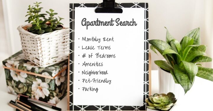 black and white clipboard with an apartment search checklist, surrounded by a floral box and plants