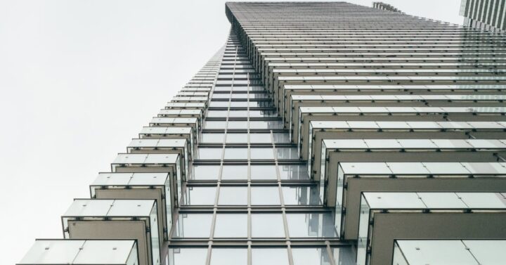 view of a tall modern apartment building looking skyward