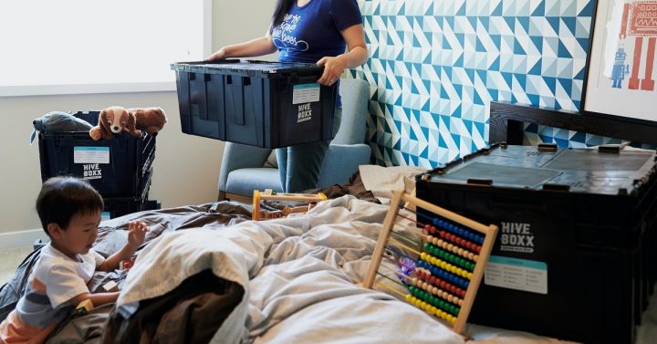 woman using eco-friendly boxes to pack up her house for a move with her young son