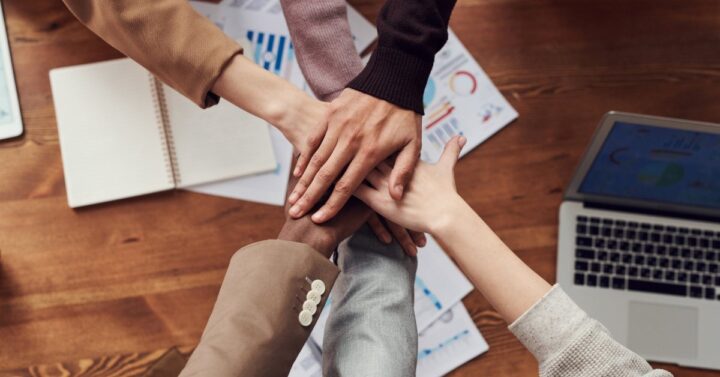 hands coming together in front of a conference table