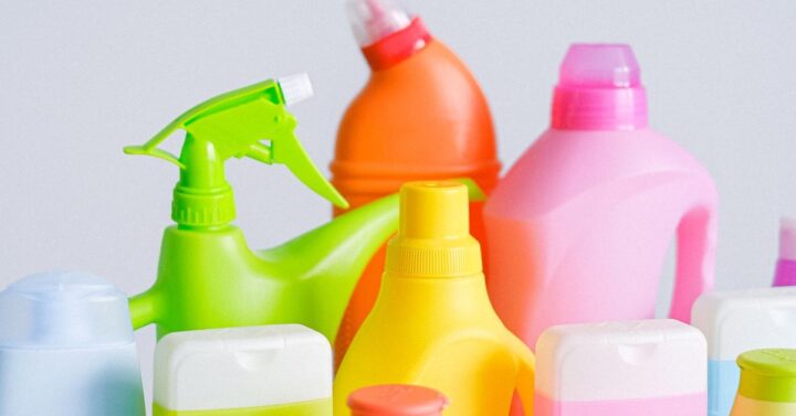 Colorful cleaning bottles and sprays lined up next to one another.