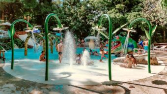 Outdoor Spray Park with children playing in bathing suits.