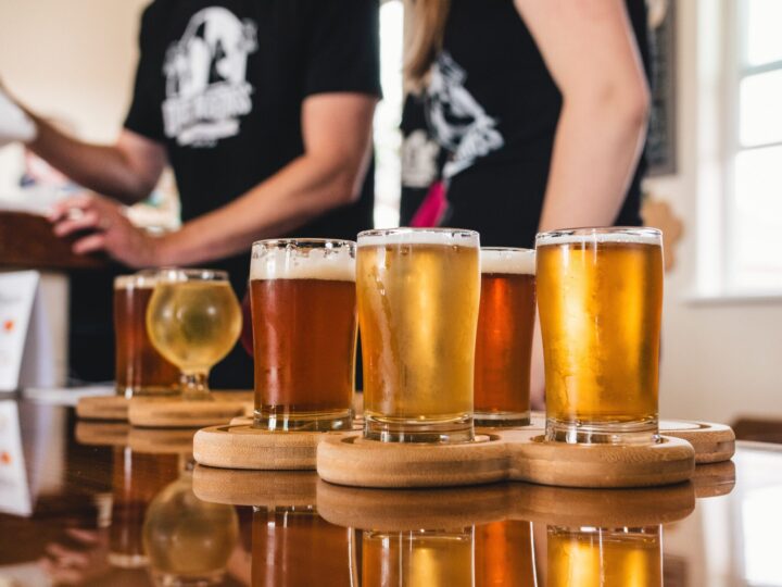 Beer flights on table with two people in background.