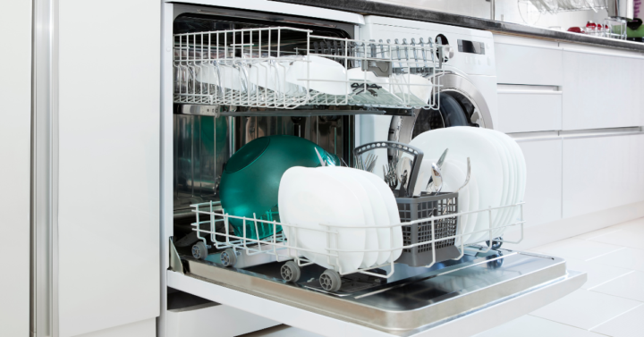 Image shows an open dishwasher full of dishes