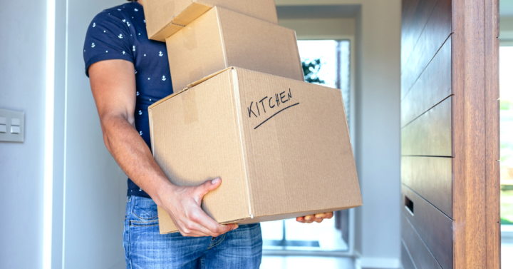 Photo of a man holding moving boxes