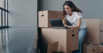 Woman on a laptop surrounded by boxes