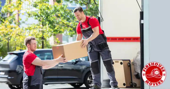 Two people carefully wrapping and packing items into moving boxes with Firehouse Movers.