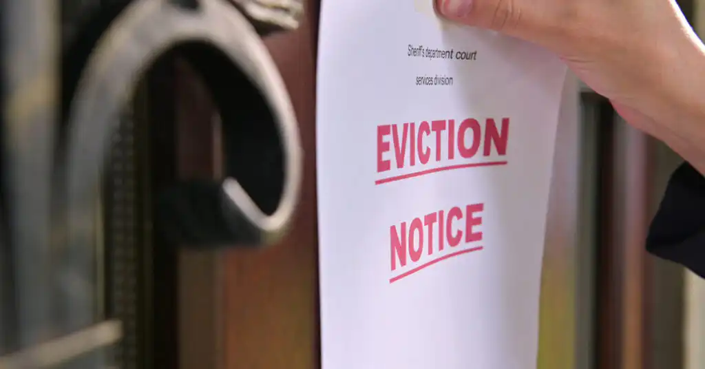 Someone posting an eviction notice on a door