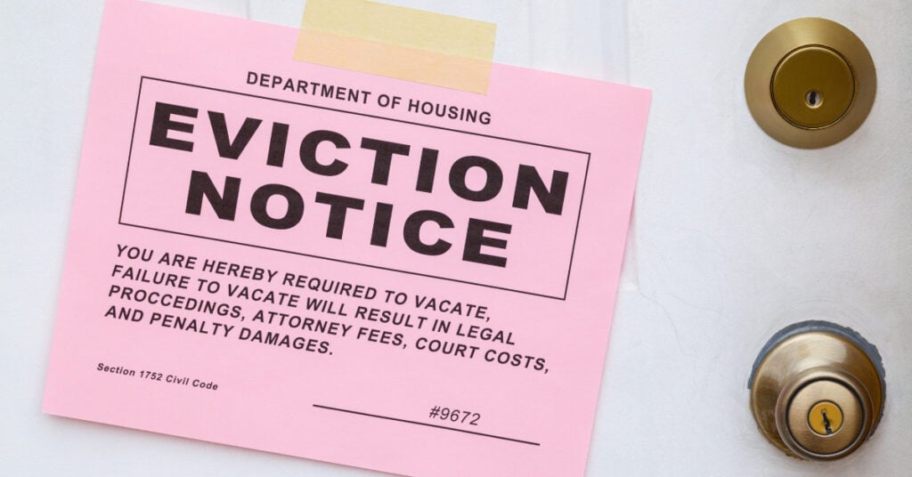 Pink eviction notice on a white door