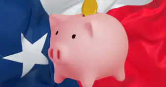 a piggy bank in front of a waving Texan flag