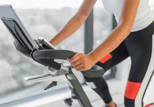 Image shows a person riding an exercise bike