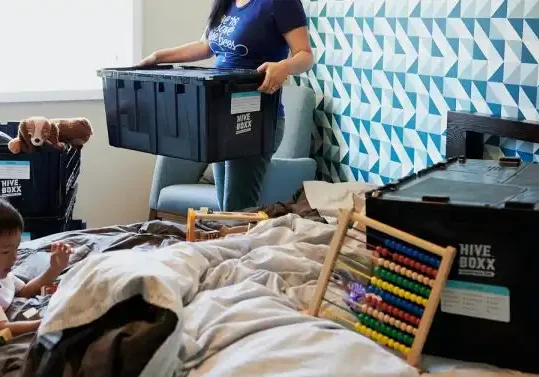 woman using eco-friendly boxes to pack up her house for a move with her young son