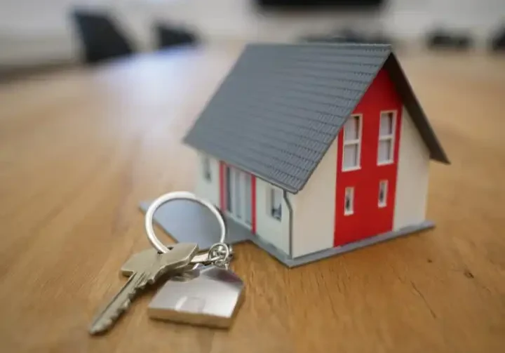 tiny house figurine with a set of keys on a table